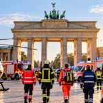 Symbolbild zur Notfallreform 2026: Rettungskräfte, Rettungswagen und ein Rettungshubschrauber vor dem Brandenburger Tor in Berlin.